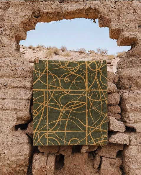 A green Shop Seif rug photographed within historic stonework