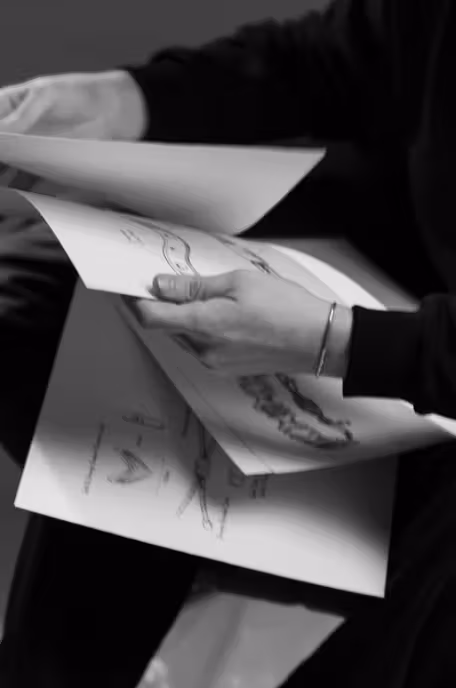 Hands reviewing original Shop Seif design drawings